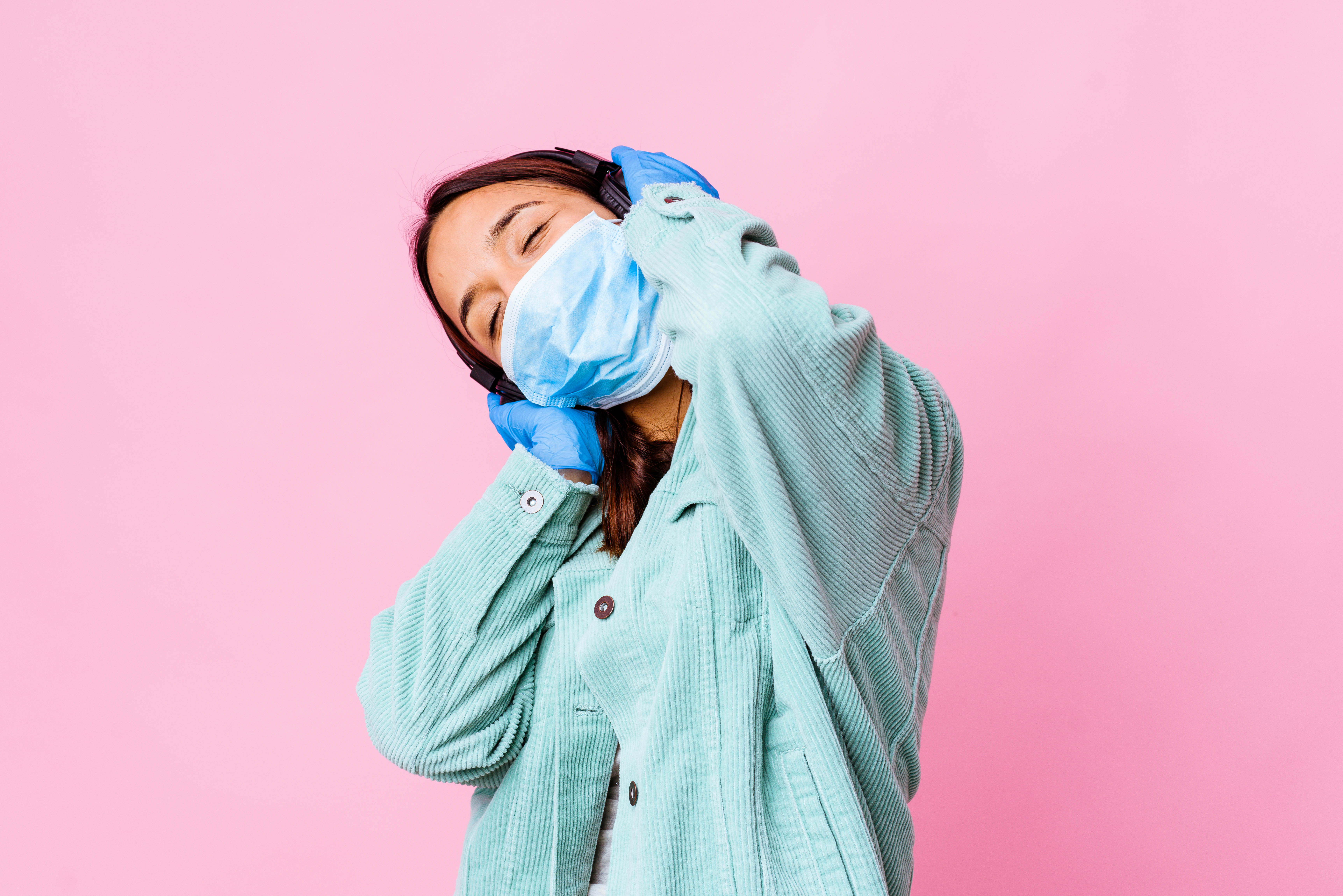 Nurse in surgical mask listening to headphones